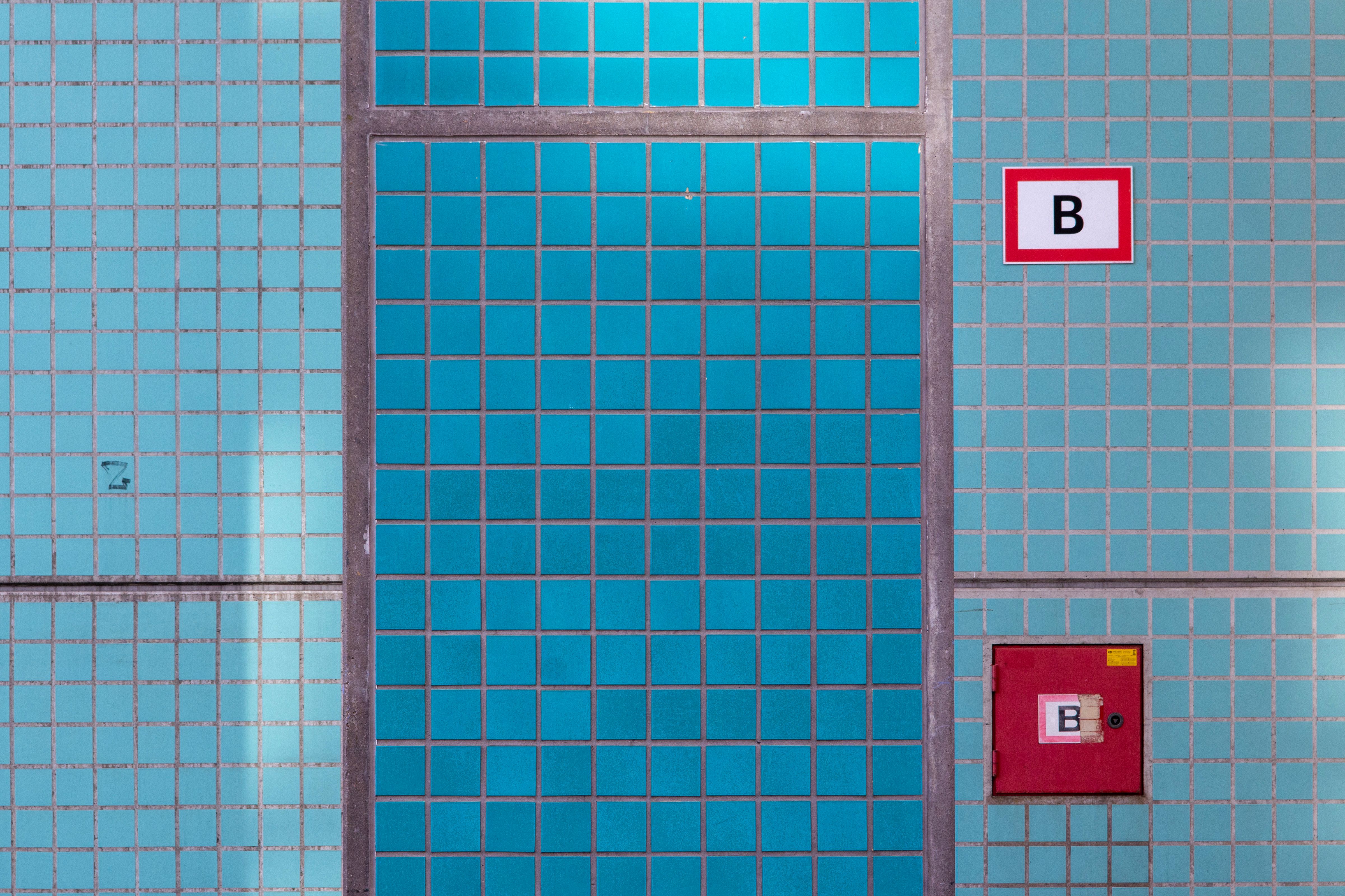 Close-up of a blue ceramic tiled wall featuring geometric patterns and signs, ideal for interior design concepts.
