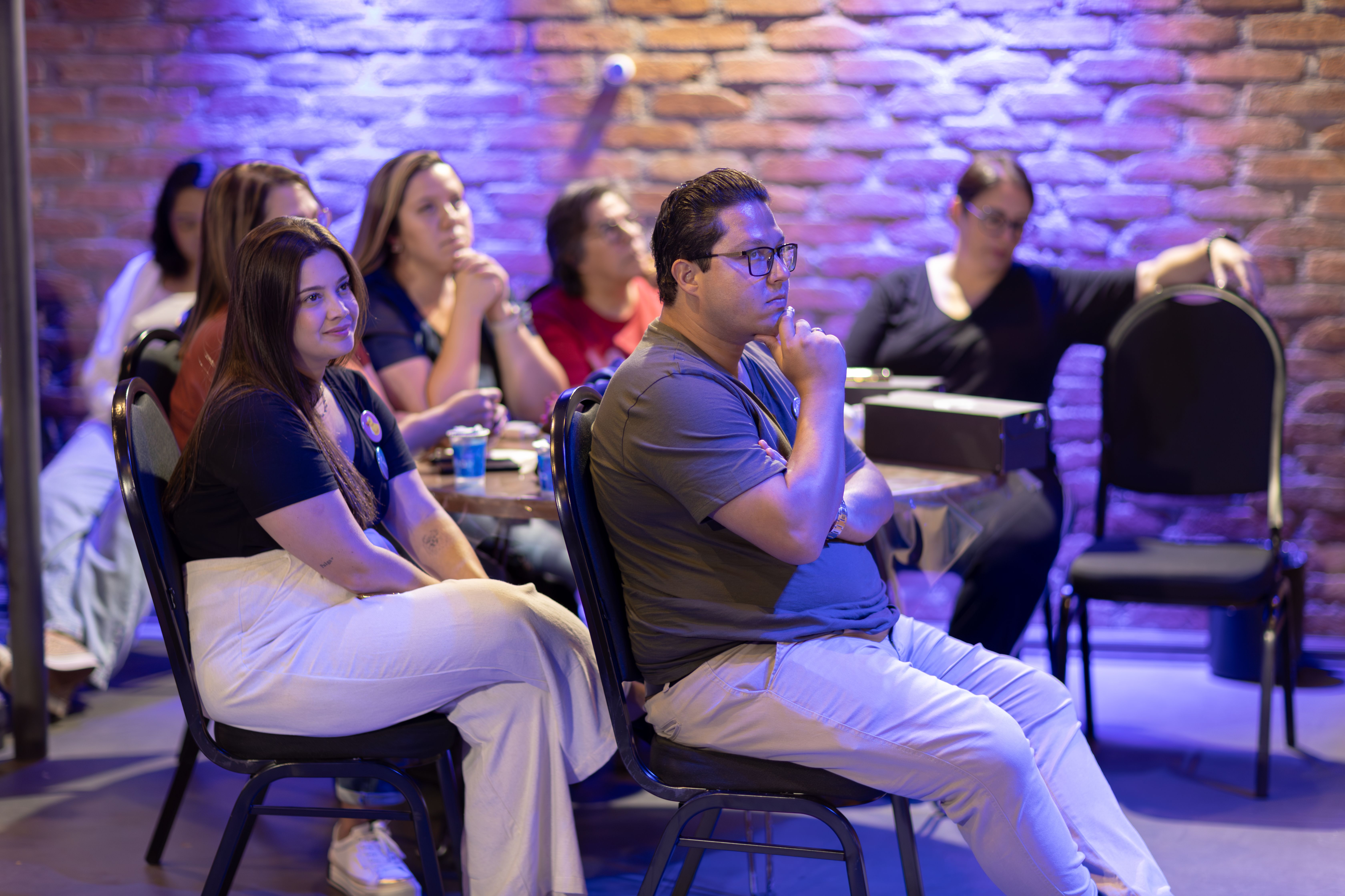Attentive audience members listening during an indoor seminar or workshop.