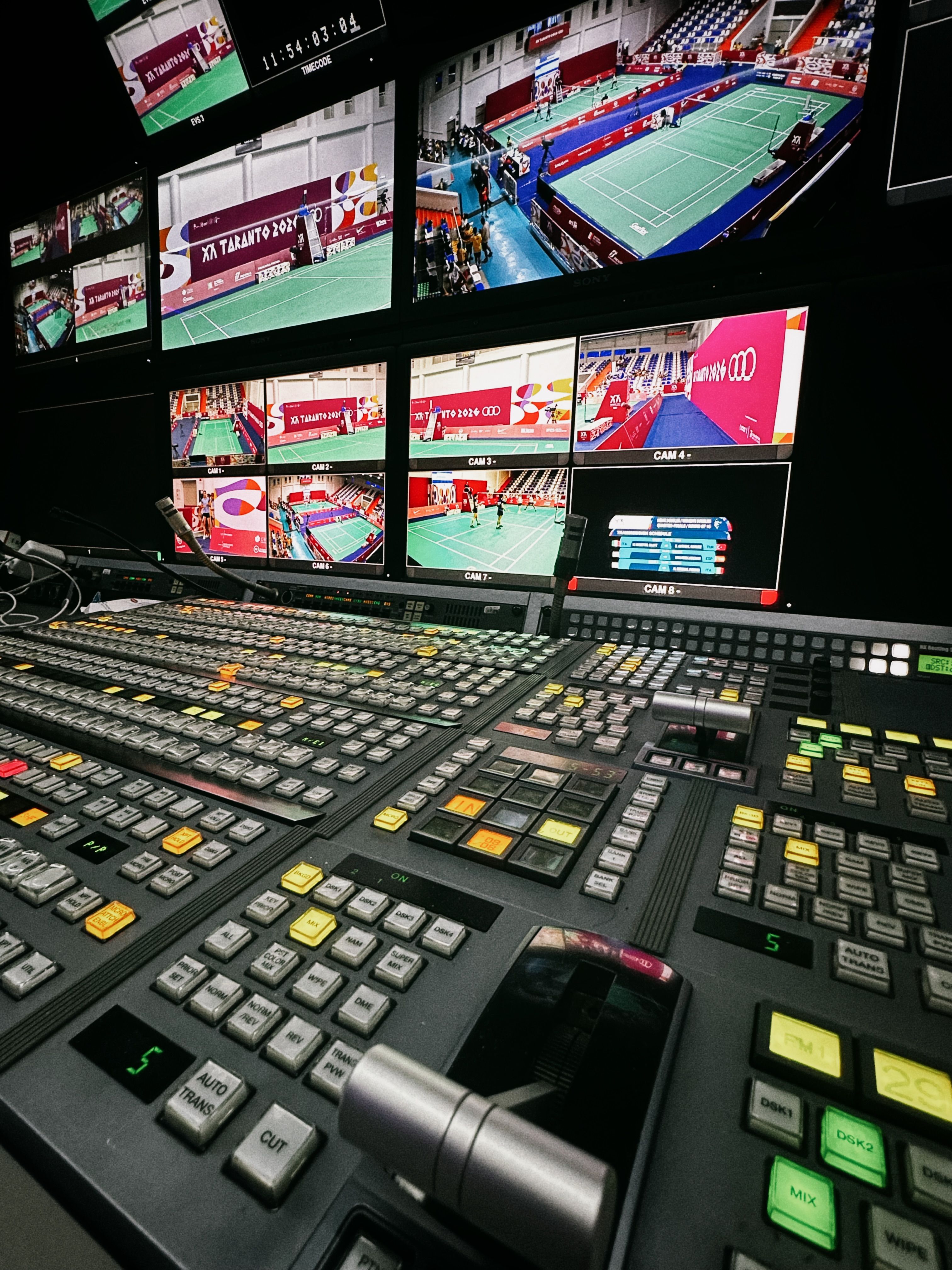 Dynamic broadcast control room with monitor screens displaying live event feeds.