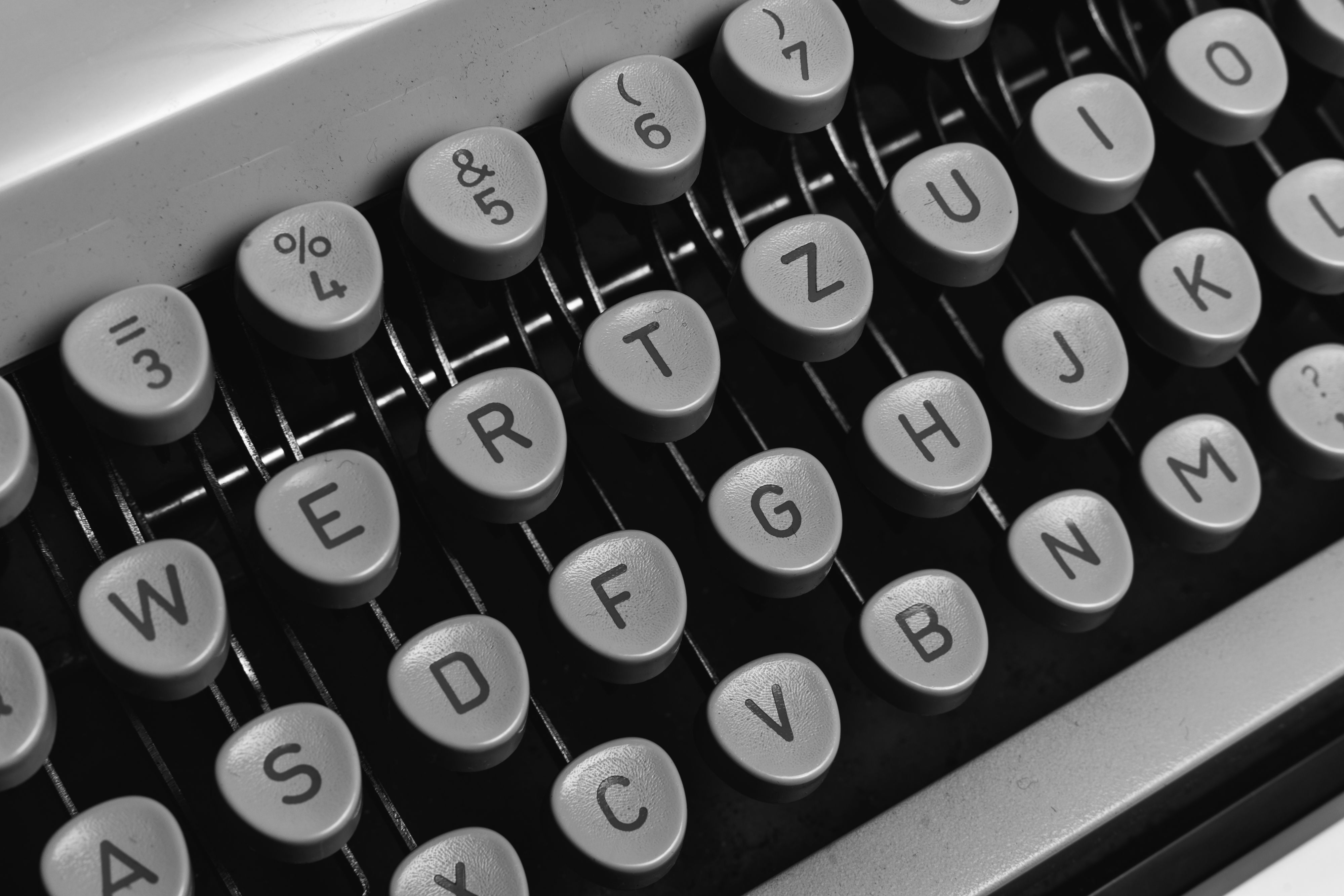Black and white close-up of classic typewriter keys, emphasizing vintage design.