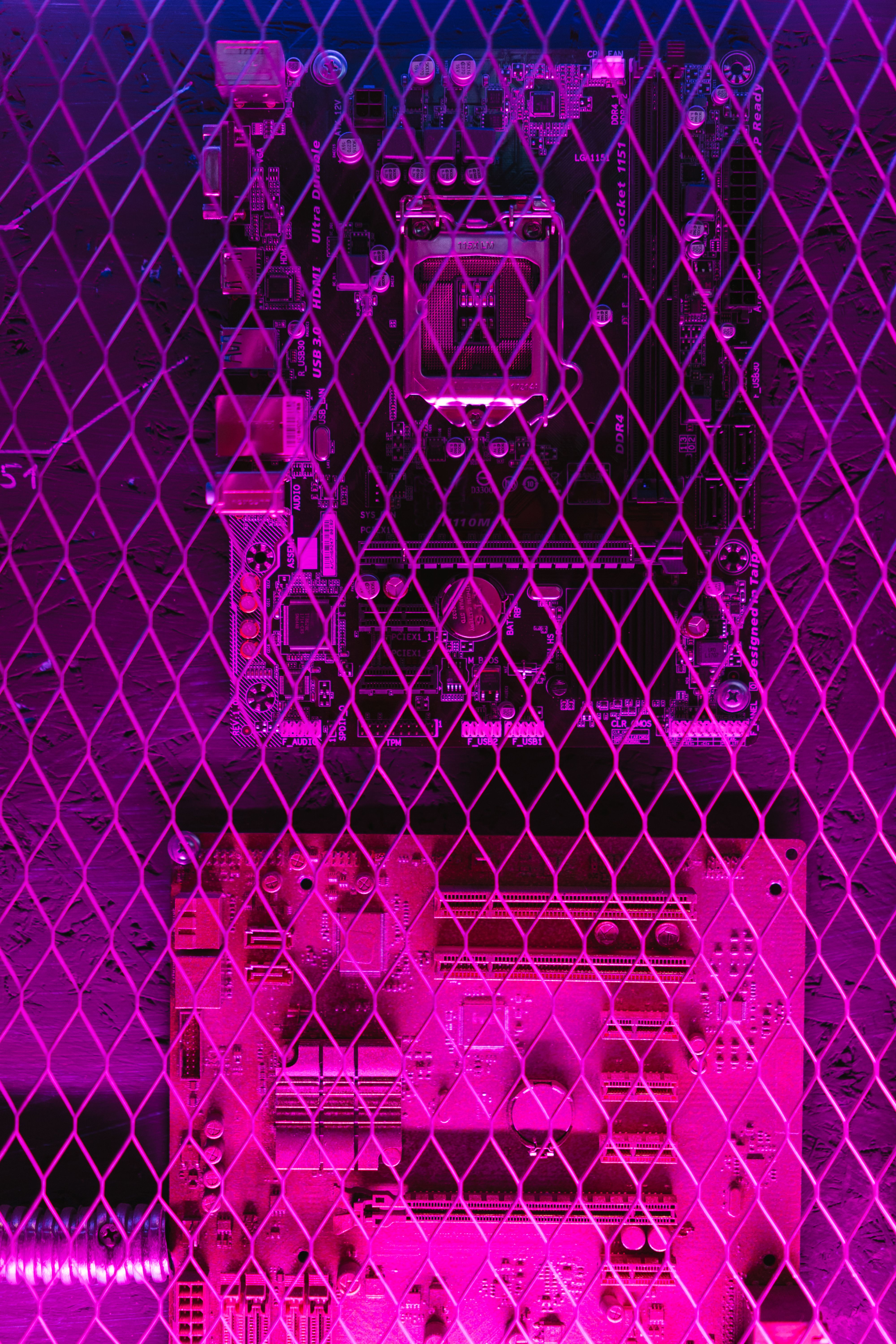 A vibrant, abstract image of a circuit board seen through a grid wire mesh, showcasing technology themes.